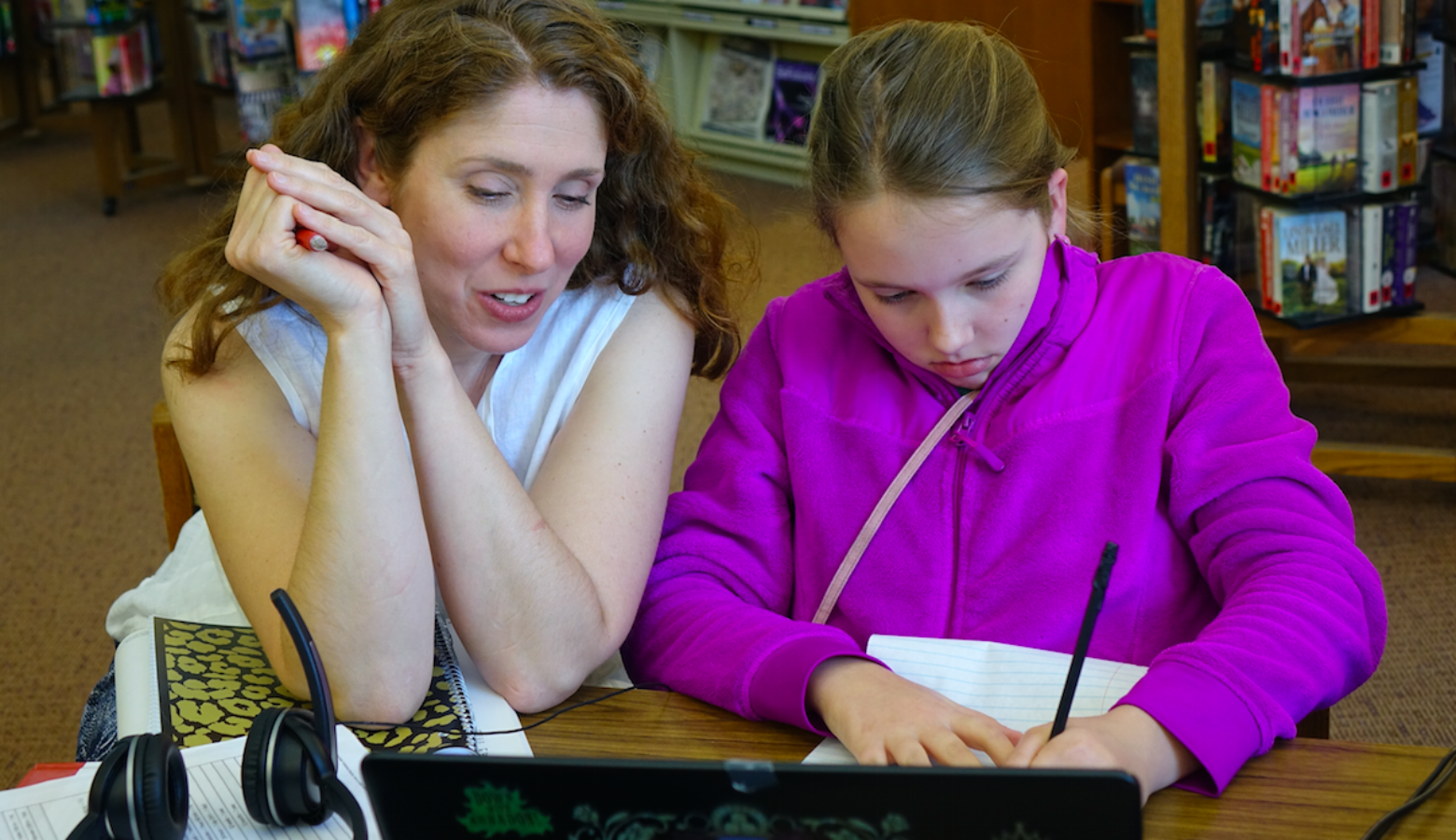 Anna Allman laughs with daughter Piper as they review German language words as part of Piper’s Hoosier Virtual Academy foreign language course at the Mooresville Public Library on April 18, 2017. Allman says she’d be devastated if the school was closed because “individual students that are being positively impacted -- such as our family.” (Eric Weddle/WFYI News)