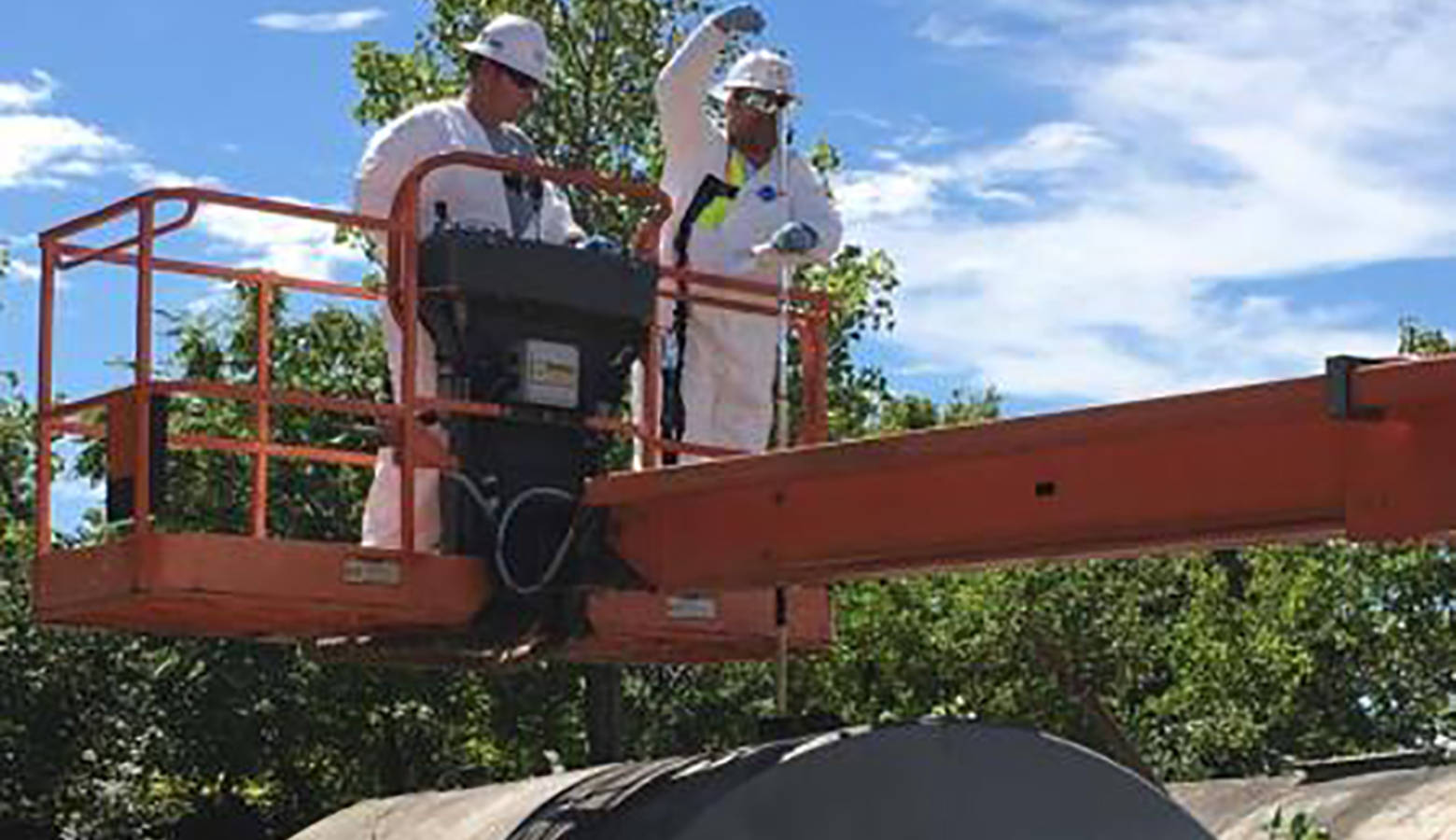 EPA contractors sample an above ground storage tank. (Photo courtesy EPA)