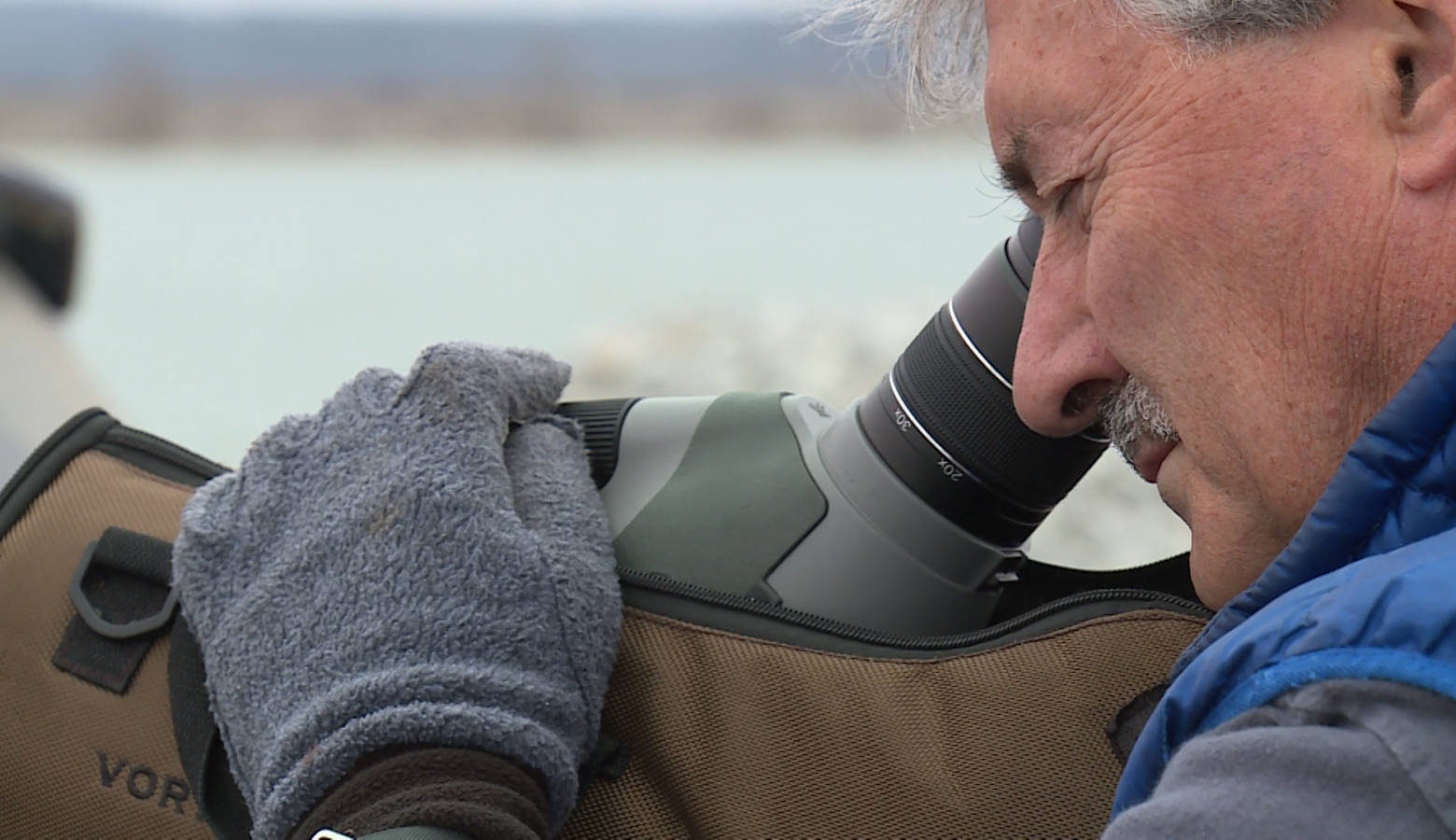 Jim Hengeveld uses a telescopic lens to count loons and other birds on Lake Monroe (Steve Burns/WTIU)