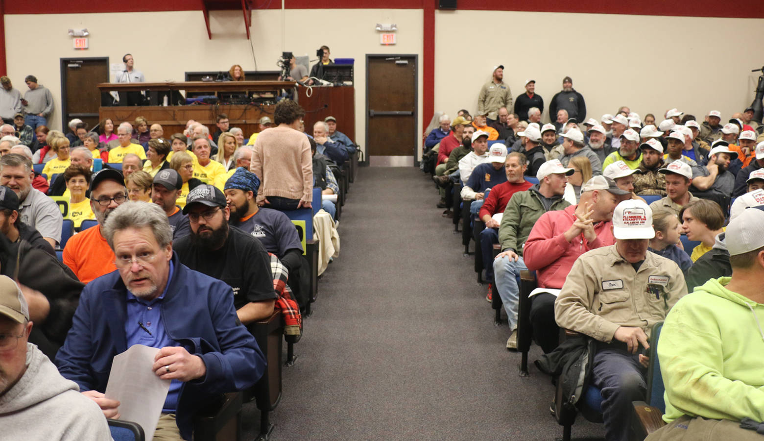 Community members gathered at hearing on an air quality permit for a proposed coal-to-diesel plant in Dale, Indiana. Opponents wore yellow shirts, union workers wore white caps as a show of support. (Isaiah Seibert/WNIN)