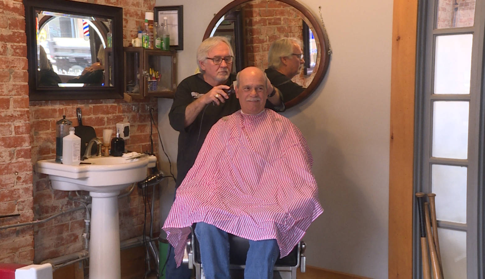 Barber Dan Fleener cuts Morgan County Commissioner Kenny Hale's hair at his shop in Martinsville (Rebecca Thiele/IPB News)