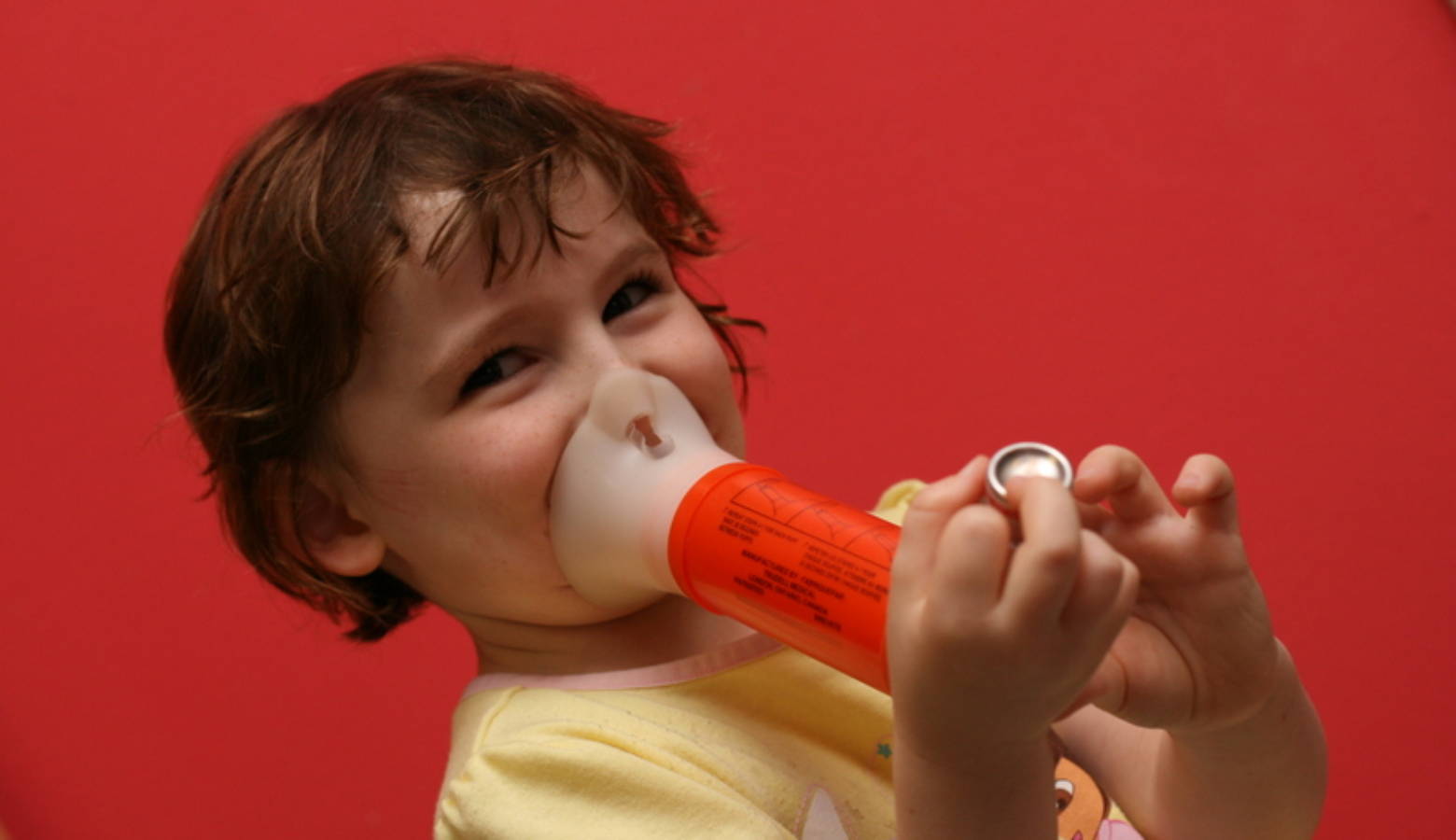 A child uses a spacer with an inhaler to treat asthma symptoms. Rising temperatures make the ozone and particle pollution that contribute to asthma problems worse (Wikimedia Commons)