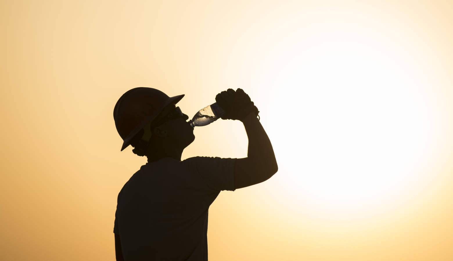 A U.S. airman drinks water while working on a construction site in extreme heat in Southwest Asia, 2017. (U.S. Air Force/Damon Kasberg)