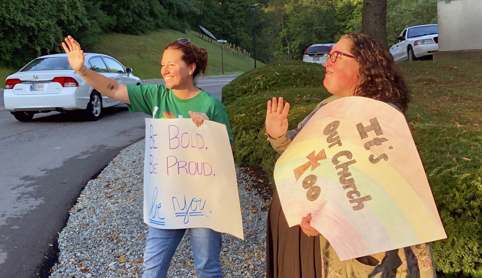 Shelly Fitzgerald waves to students entering Cathedral High School's campus. Fitzgerald was a guidance counselor as Roncalli High School before being put on administrative leave last year due to her same-sex marriage. (Darian Benson/WFYI)