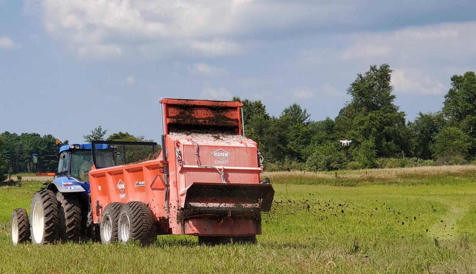 Companies demonstrate their solid manure spreaders out in the field to expo attendees. (Samantha Horton/IPB News)
