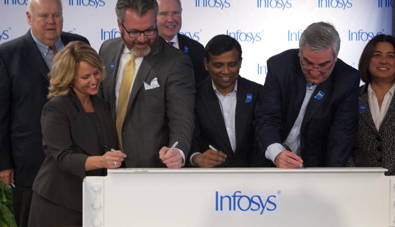 State and local officials along with Infosys company leaders sign a beam commemorating the progress to its U.S. Educational Center in Indianapolis. (Samantha Horton/IPB News)
