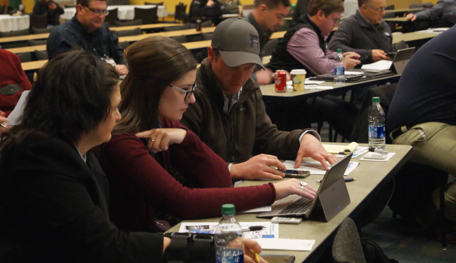 (Left to right) Kayla Holscher, Jenna Lansing and Andy Hruby work as a group during the Ag Survivor simulator activity at Purdue University's Top Farmer Conference. (Samantha Horton/IPB News)