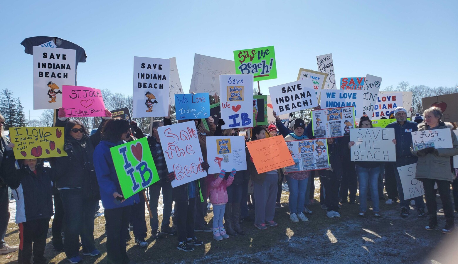 Attendees at Saturday's rally hold signs in support of saving Indiana Beach. (Samantha Horton/IPB News)