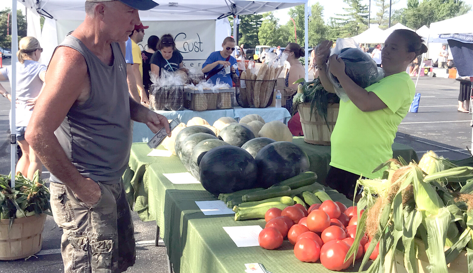 A customer purchases produce at the 2018 Columbus farmers market. (Lauren Bavis/Side Effects Public Media)