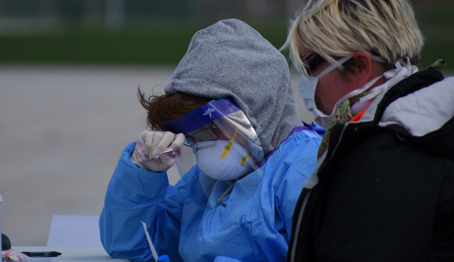 Employees doing COVID-19 testing wear considerable amounts of personal protective equipment. (Justin Hicks/IPB News)