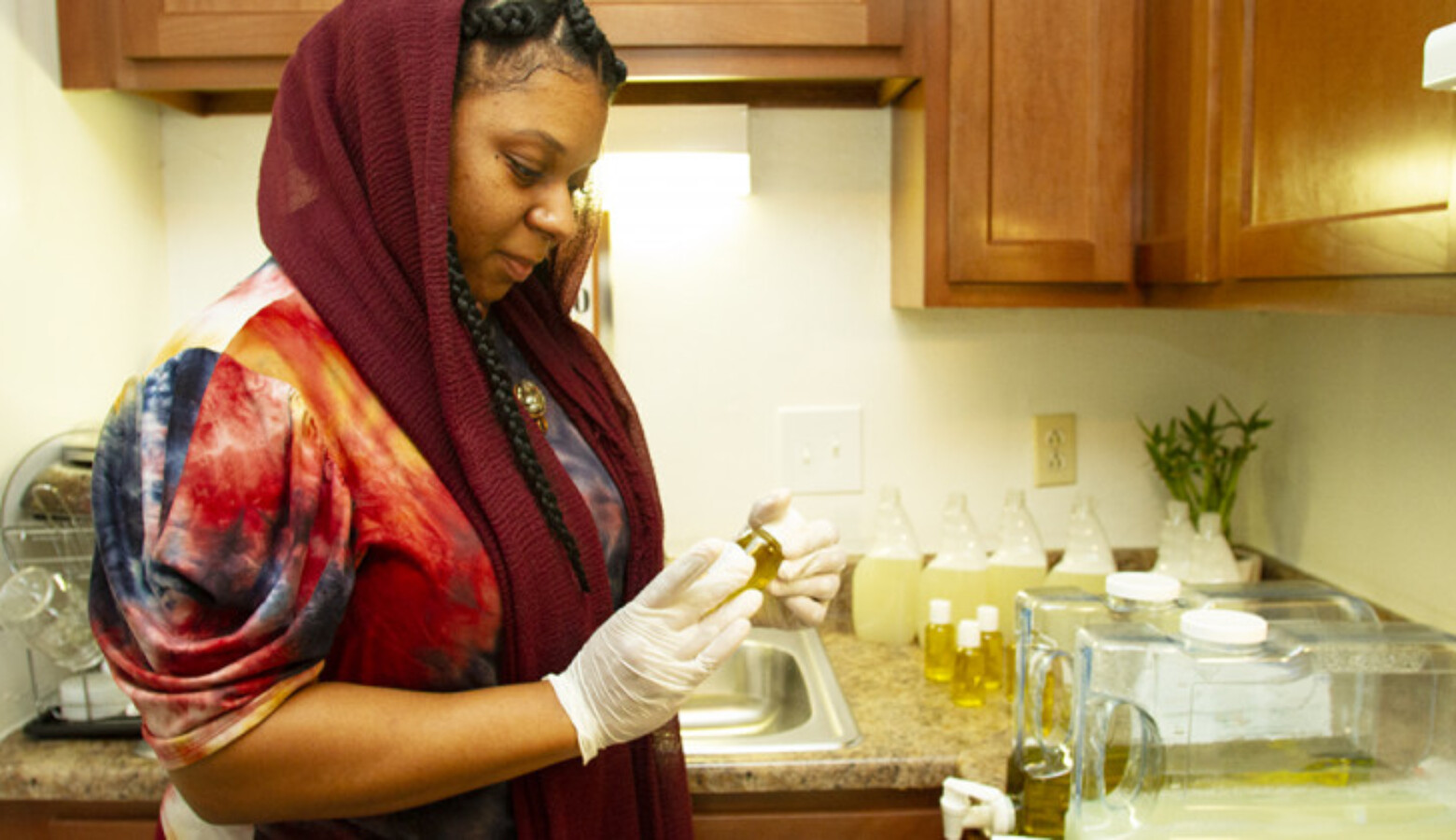 La'Kiyah Muhammad prepares her all-natural baby oil and multi-purpose spray in her kitchen. While Muhammad first started her business five years ago, she's refocusing her energy on its growth during the pandemic.