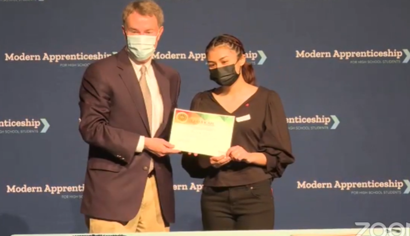 Indianapolis Mayor Joe Hogsett poses for a photo with Ben Davis High School student Ruby Galvan. Galvan will be an apprentice with the city government.  (Screenshot facebook.com/EmployIndy/videos/312002257147118)