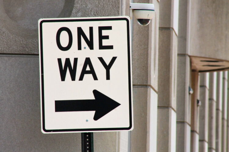 A road sign reads "One Way" with an arrow pointing to the right.