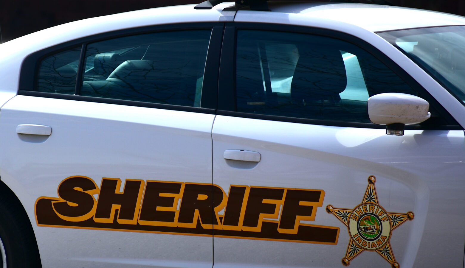 A law enforcement vehicle with "Sheriff" and a star symbol along its side.