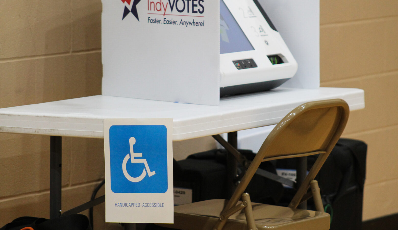 A voting booth with a blue accessibility sign posted to the table.