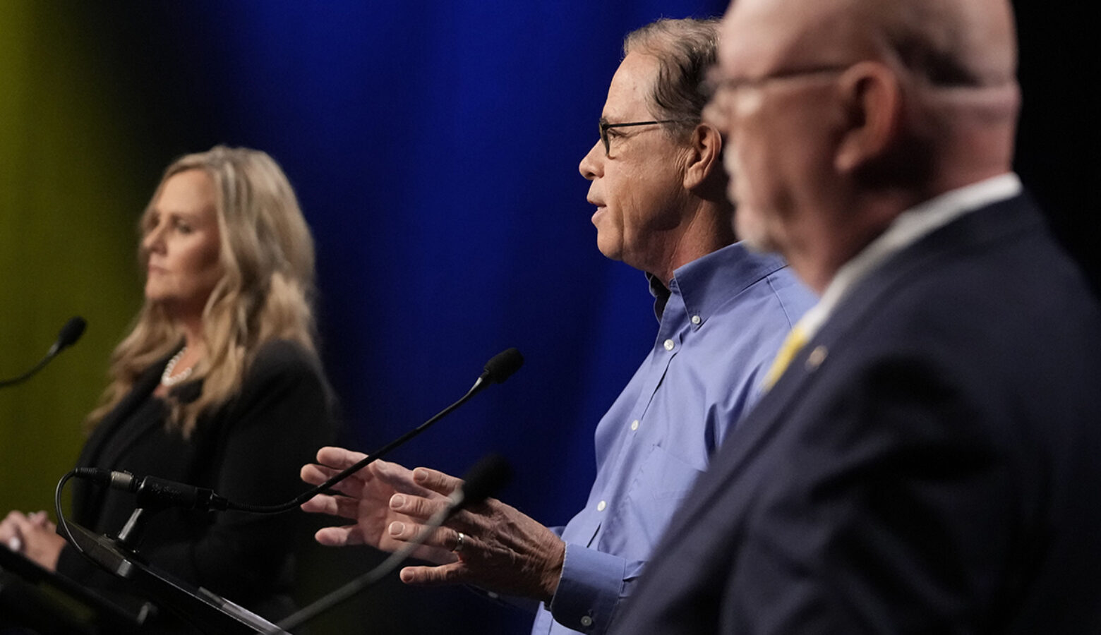 Jennifer McCormick is a White woman with blonde hair, wearing a black suit. Mike Braun is a White man, balding with gray hair. He is wearing glasses and a blue shirt. Donald Rainwater is a White man, bald, with a white goatee. He is wearing glasses and a dark suit.