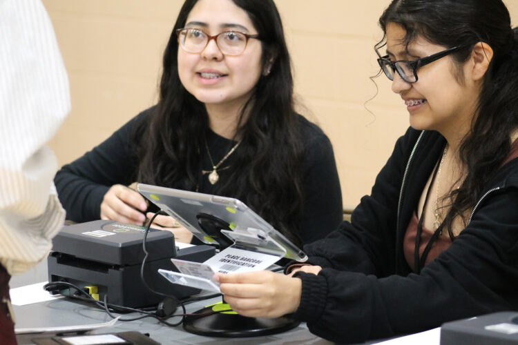 Two high school students check an ID.